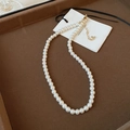 Macro view of a single-strand pearl necklace with gold-plated lobster clasp and extender - 8mm/Pack / White