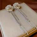 Macro detail of silver flower earrings with cascading rhinestone tassels and petals - Silver Tone Rose Flower Tassel Earrings (Silver Pin)