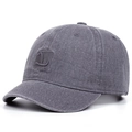 Dettaglio del tessuto in cotone lavato grigio scuro di un cappello con visiera corta e logo - Grigio