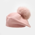 Close-up of pink knit beret featuring thick texture and fluffy pompom detail - Pink