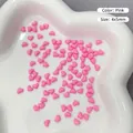 Makroaufnahme von 4x5mm rosa Herzanhängern aus Harz für Nagelkunst auf Tablett - Rosa