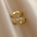 Primo piano di ear cuff a C placcati oro con motivo a nido d'ape su seta color champagne - Clip per Orecchio a Forma di C in Zircone Dorato