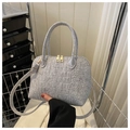 Close-up of grey felt shell bag featuring faux crocodile texture and gold-tone hardware - Gray