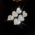 Close-up of heart-shaped rhinestone earrings with sparkling silver tassels in a macro view - Silver Rhinestone Triple Heart (Silver Needle)