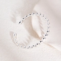 Gros plan d'un bracelet en métal argenté à spirales avec un design torsadé poli - Bracelet manchette ouvert torsadé en spirale argenté