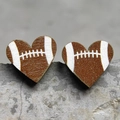 Dettaglio macro di orecchini a cuore in legno con motivo football americano su pietra - Football Americano Cuore