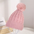 Detail of pink knit beanie featuring cable knit texture and large fluffy pom-pom detail - Pink
