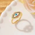 Anello aperto dorato con design malocchio in zircone colorato su piatto bianco - Stile B-Occhio di Zirconi Multicolore