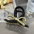 8cm black resin bow hair claw clip with golden cross patterns on metal table - Black Claw Clip / Gold Bowknot