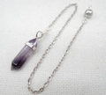 Macro detail of hexagonal amethyst crystal pendulum pendant with silver chain and metal bead - Amethyst