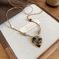 Detail of leopard print resin heart pendant on brown cord with golden edge accents - Heart Shape (Resin) / Coffee