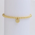 Close-up of golden beaded bracelet with a V letter pendant on a white display stand - Letter V (DB240603-V)