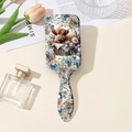 Detail of avocado green hairbrush featuring highland cow and floral pattern illustration - Style A