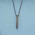Gros plan d'un pendentif barre noire avec pierre bleue carrée et sa chaîne noire en métal - Longueur de chaîne 50+5cm / Noir Homme (Zirconia Bleu)