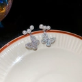 Macro shot of silver butterfly earrings with sparkling cubic zirconia and white pearls - Silver Butterfly Pearl (30#)