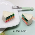 Macro shot of miniature rainbow sandwich cake resin charms showing detailed colorful layers - Rainbow Triangle