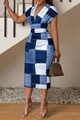 Close-up of a V-neck printed dress with a patchwork pattern on a model indoors - Denim Blue Plaid Print