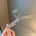 Large ice-blue hair claw clip held by hand, featuring a sleek twisted resin design - Jelly Gray-13cm (Strengthened)