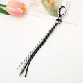 Detail shot of black and white woven phone lanyard on a desk with a tulip decoration - Black and White Style (K3886)