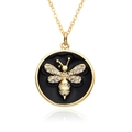 Close-up of gold bee pendant with crystal accents on a circular black background - Black Enamel Bee Rhinestone Style (D556)