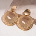 Macro detail of gold metal hollow hoop earrings with sunburst texture on stone - Gold