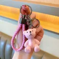 Close-up of pink resin bear keychain with woven leather strap and lobster clasp detail - Pink