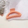Close-up of matte coral pink large shark clip with anti-slip teeth on white paper - Semi-circle / Orange Pink