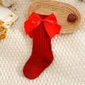 Close-up of red Christmas baby socks featuring vertical stripes and a large satin bow - XS (0-1 Years) / Red