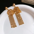 Dettaglio di orecchini a nappa dorata con design a sfere su un piatto bianco - Paillettes Oro Placcate Oro Vero (43#)