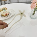 Close-up of a pearlescent white acetate hair fork with a green rhinestone flower detail - Pearl White Flower Style (White Mermaid Pearl)