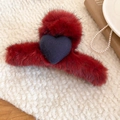Dettaglio di una molletta per capelli in peluche rosso con cuore su tessuto bianco - Molletta per capelli a fiore rosso