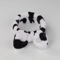 Macro detail of plush black and white cow print headband with soft coral fleece texture - Cow Print