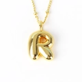 Macro shot of 3D balloon-style letter R pendant in polished gold finish for hip-hop necklace - Letter R