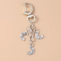 Llavero retro de aleación plateada con colgantes de luna y estrella en fondo beige - Plata Antigua