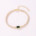 Detailed view of gold tennis bracelet featuring CZ stones and green center emerald - Rectangular Style (Green Rhinestone) / Gold