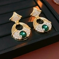 Détail de boucles d'oreilles dorées vintage avec pierre verte ovale et strass étincelants - Tige en Argent - Vert Doré