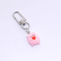 Close-up of a cute pink resin pig keychain with a silver metal clasp on white background - Heart Pig