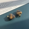 Macro shot of heart-shaped tiger eye stone pendants with golden metal clasps - Tiger's Eye