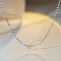 Vue macro d'une fine chaîne à maillons argentés montrant la texture du métal poli - Argent 925 / Style de Chaîne de Croix (XL026)
