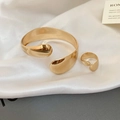Detailed view of polished gold minimalist open bracelet and matching ring on silk fabric - Irregular Wide Mirror Set / Gold