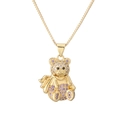 Close-up of golden teddy bear pendant with purple and pink gemstones on box chain - Purple