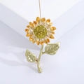 Détail d'une broche tournesol élégante avec pétales en émail jaune et centre en cristal - Jaune clair