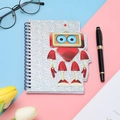 Detail of spiral bound notebook with silver glitter cover and 3D cartoon robot mascot - Robot