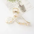 Minimalist oversized bow hair claw clip in amber resin finish with gold accents - Champagne