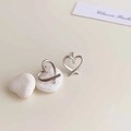 Macro shot of 925 sterling silver heart-shaped earrings on smooth white stones - Rhodium Plated Silver Hollow Heart Earrings