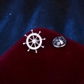 Silver nautical helm brooch badge on red velvet lid with a professional bokeh background - Silver Ship Helm