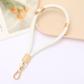 Detail of cream white PU leather wrist strap with gold lobster clasp and metal rings - White