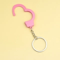 Miniature pink plastic handcuff keychain with a metal ring on a yellow background - Pink Single Handcuff
