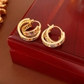 Primer plano de pendientes vintage de oro con piedras preciosas en joyero de madera - Orejera Multicolor Bañada en Oro