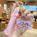 Pink sakura keychain with floating beads in a clear flower charm and Happy Day strap - Pearl Sakura - Purple